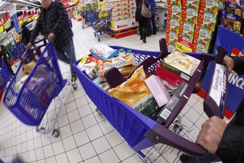 © Reuters. Customers push shopping trolleys down an aisle at Carrefour Planet supermarket in Nice Lingostiere