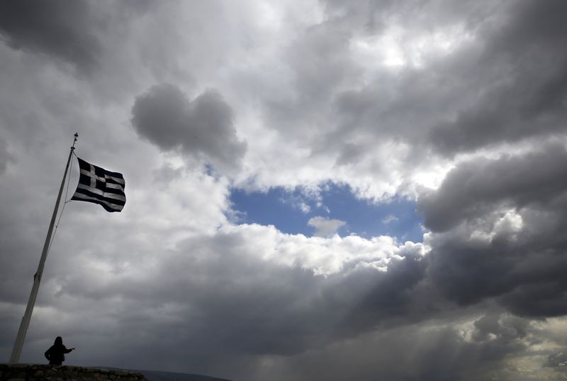 © Reuters. Turista posa perto de bandeira da Grécia na Acrópole, em Atenas