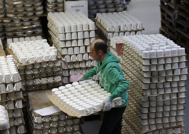 © Reuters. A worker carries cups in the storage facility at the Portmeirion Factory in Stoke-on-Trent