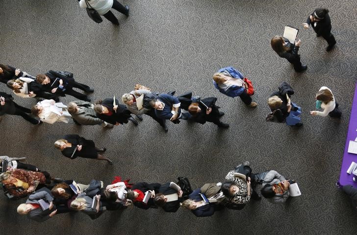 © Reuters. Hundreds of job seekers wait in line with their resumes to talk to recruiters at the Colorado Hospital Association health care career fair in Denver