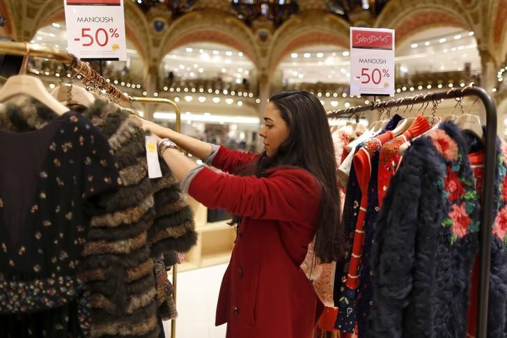 © Reuters. A  shopper walks through the aisles of the Galeries Lafayette department store to select items to purchase, as part of a special event on the eve of the start of winter sales, in Paris