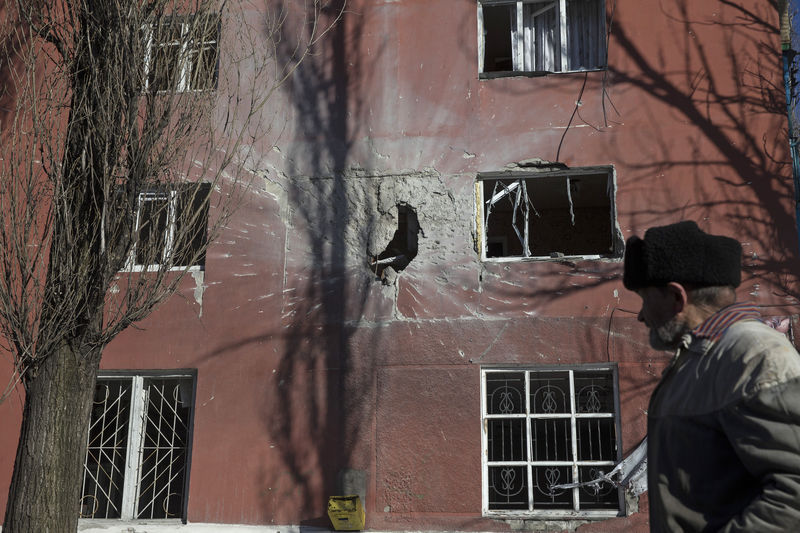 © Reuters. Homem passa por edifício danificado por combates na cidade de Vuhlehirsk, perto de Debaltseve