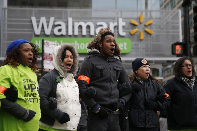 © Reuters. Wal-Mart protesters link arms during a demonstration in Chicago