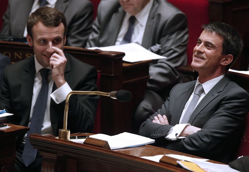 © Reuters. French Prime Minister Valls and Economy Minister Macron attend a session before a no-confidence vote against French government at the National Assembly in Paris