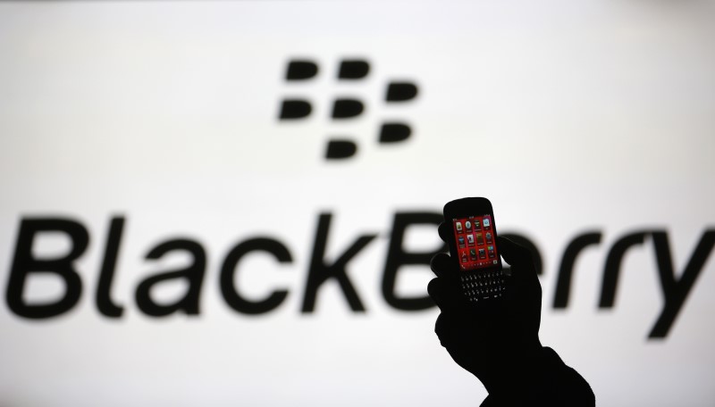 © Reuters. File photo of a man silhouetted against a video screen with Blackberry logo as he poses with Blackberry Q10 in the central Bosnian town of Zenica