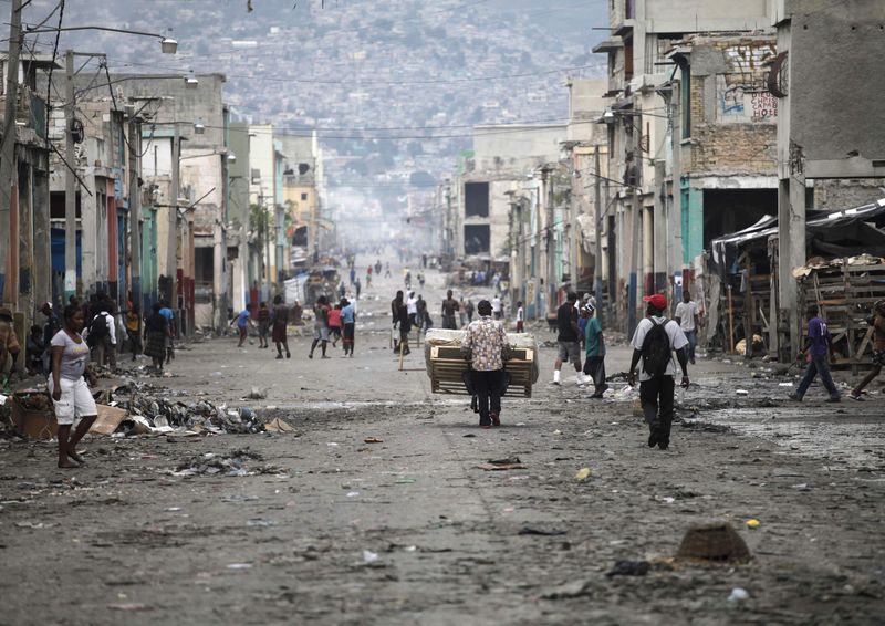 © Reuters. Haitianos caminham por uma das ruas principais de Porto Príncipe