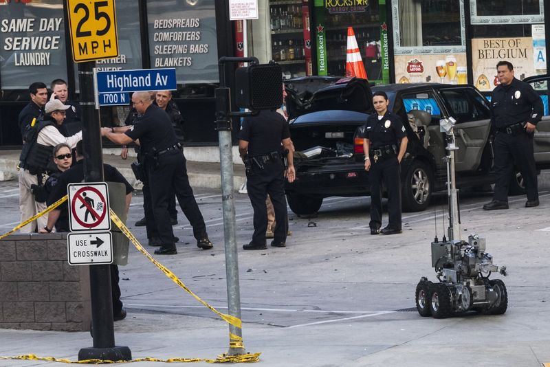 © Reuters. Policiais cercam um veículo enquanto robô deixa o local de uma ameaça de bomba em Hollywood