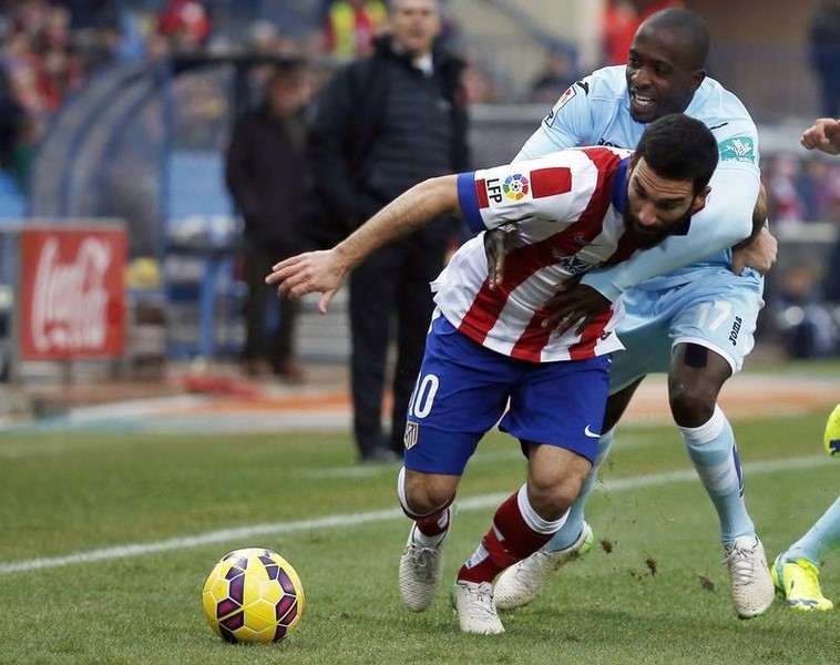 © Reuters. Atletico Madrid's Turan and Granada's Sissoko figth for the ball during their Spanish first division match in Madrid