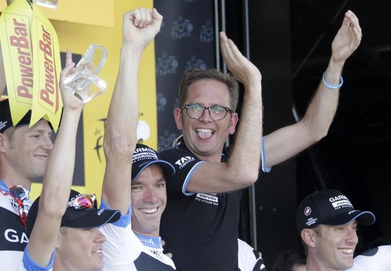 © Reuters. Garmin-Cervelo team manager Jonathan Vaughters celebrates on the podium with riders after they won the team time trial second stage of the Tour de France in Les Essarts