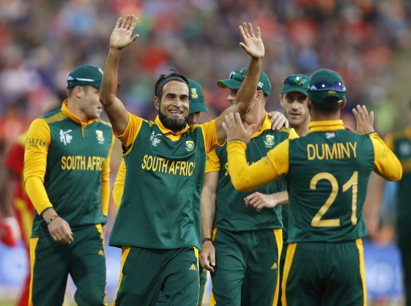 © Reuters. South Africa's Tahir celebrates with Duminy after dismissing Elton Chigumbura during their Cricket World Cup match against Zimbabwe in Hamilton