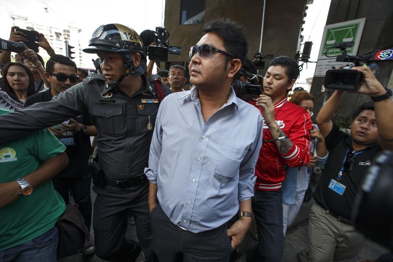 © Reuters. A Thai pro-democracy protester is detained by a police officer near Victory Monument in Bangkok