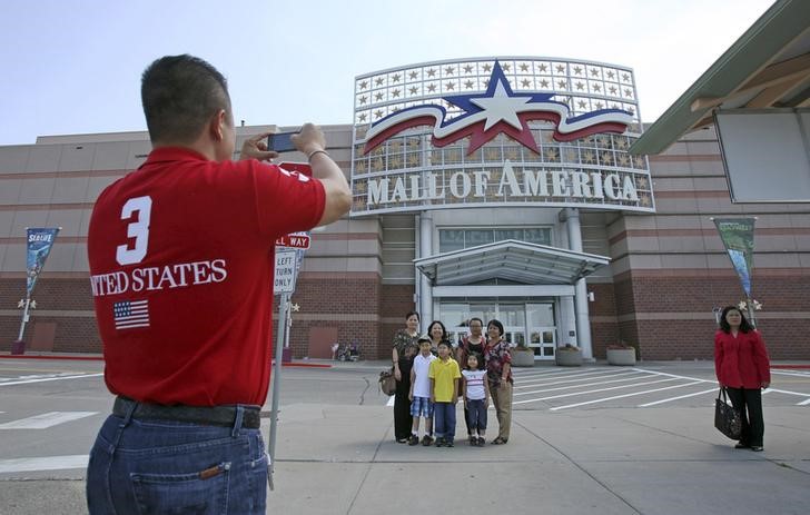 © Reuters. Family poses for a souvenir photograph in front of an entrance to the Mall of America