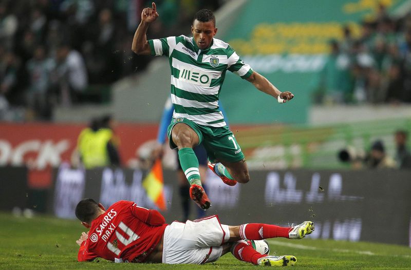 © Reuters. Sporting's Nani is tackled by Benfica's Maxi Pereira during their Portuguese premier league soccer match at Alvalade stadium in Lisbon