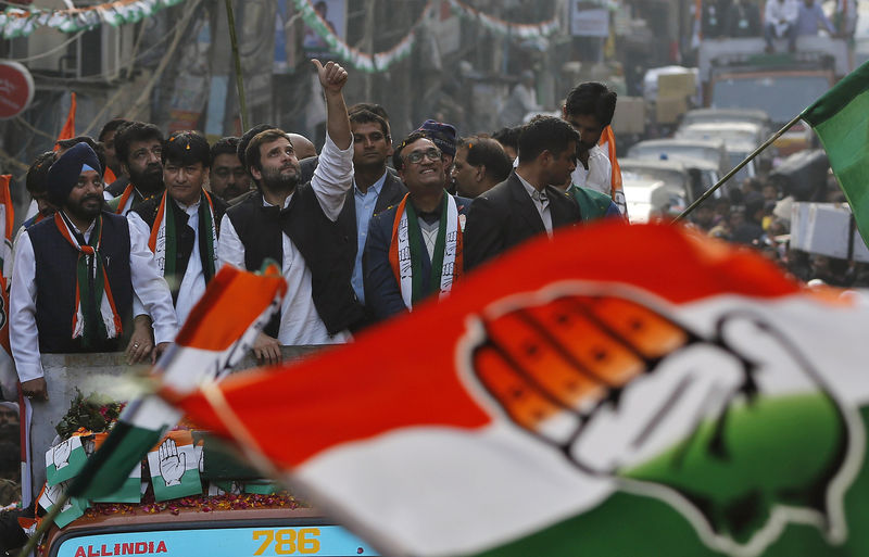 © Reuters. India's Congress party vice president Rahul Gandhi gestures as he stands a top a vehicle during a road show ahead of state assembly elections in old quarters of Delhi