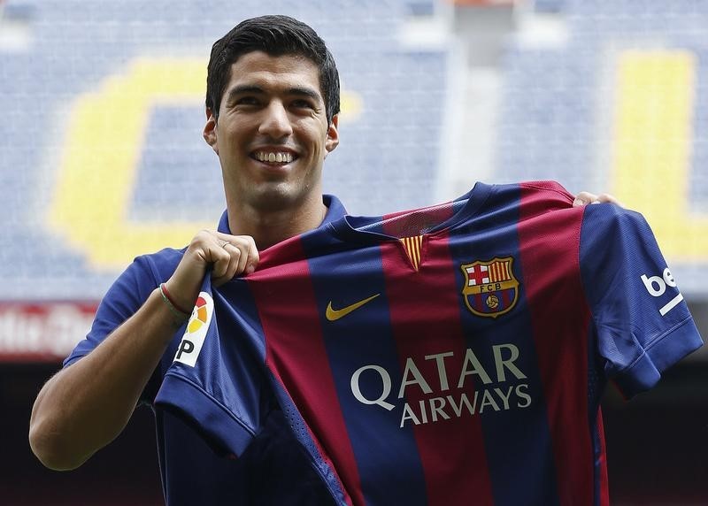 © Reuters. FC Barcelona's Luis Suarez holds up his jersey during his presentation at the Nou Camp stadium in Barcelona