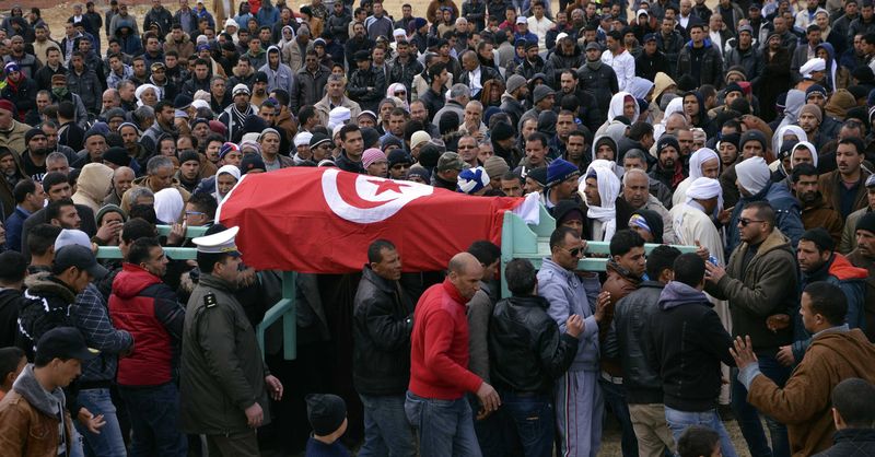 © Reuters. Familiares e colegas carregam caixão de polical morto na região de Kasserine, na Tunísia