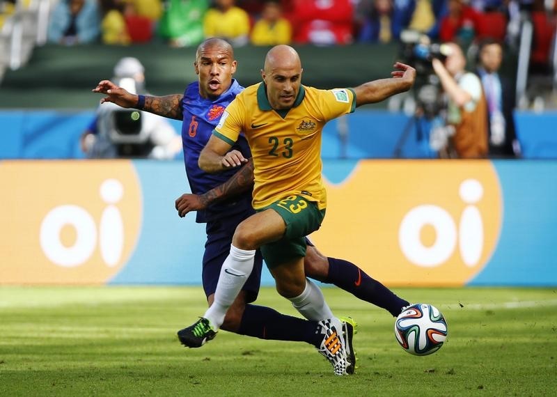 © Reuters. De Jong of the Netherlands fights for the ball with Australia's Bresciano during their 2014 World Cup Group B soccer match at the Beira Rio stadium in Porto Alegre