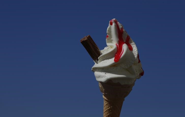 © Reuters. An ice cream cone is held against a blue sky in Blackpool
