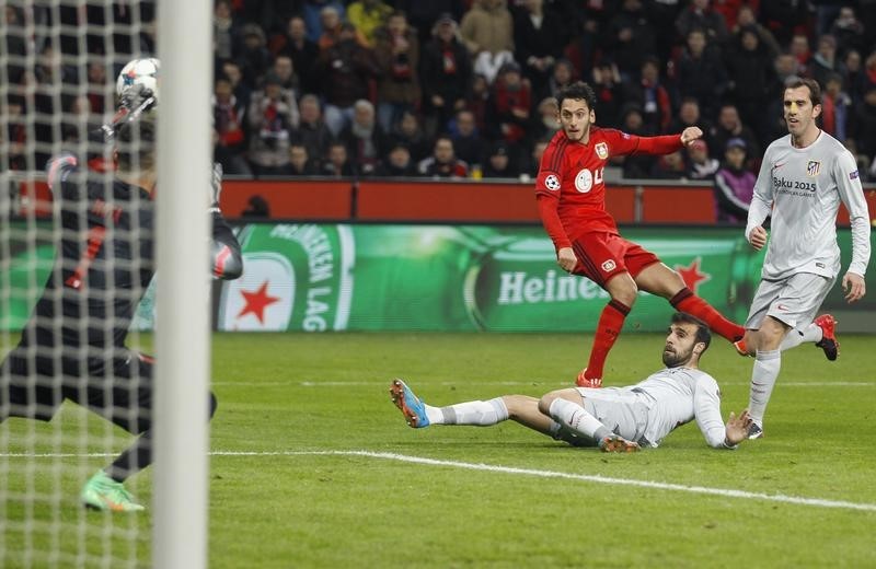 © Reuters. Hakan Calhanoglu (centro) marca para o Bayer Leverkusen contra o Atlético de Madri em partida pela Liga dos Campeões na Alemanha