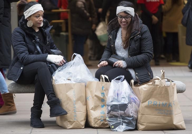 © Reuters. Shoppers take a break with their purchases on Oxford Street in central London