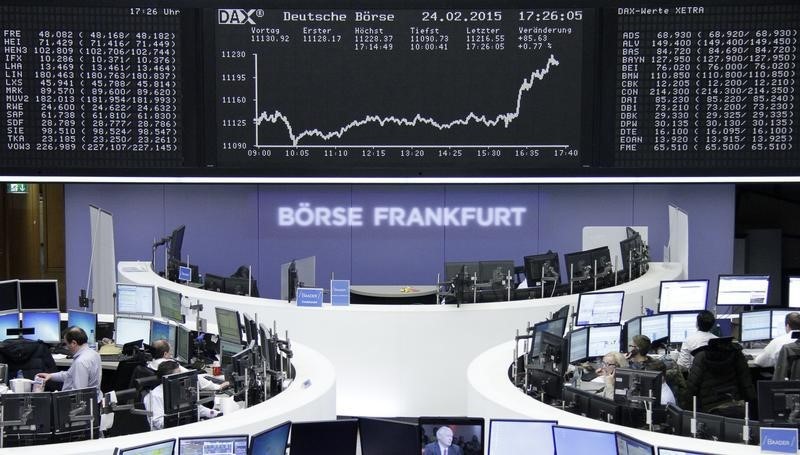 © Reuters. Traders are pictured at their desks in front of DAX board at Frankfurt stock exchange