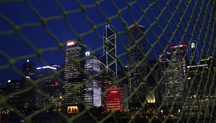 © Reuters. Skyscrapers at Hong Kong's central business district are seen behind a net near a construction site moments after sunset