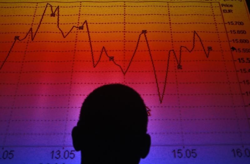 © Reuters. Силуэт человека на фоне графика индекса итальянского фондового рынка 