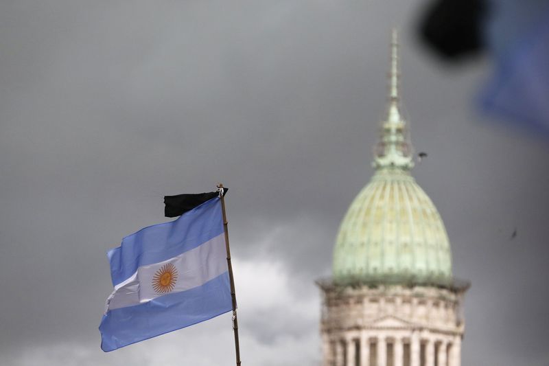 © Reuters. A black ribbon is seen on a national flag with the National Congress building in the background during a silent march to honour late state investigator Alberto Nisman in Buenos Aires