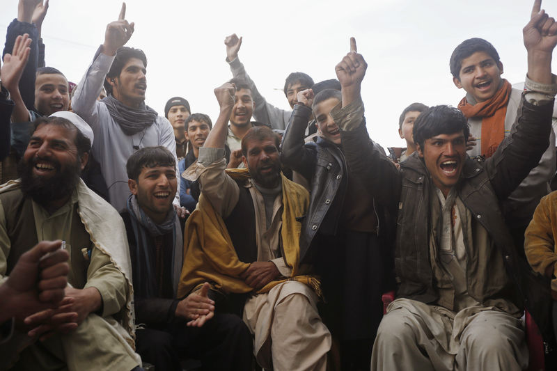 © Reuters. Fans watch the live broadcast of the Cricket World Cup match between Afghanistan and Bangladesh, at a roadside stall in Kabul