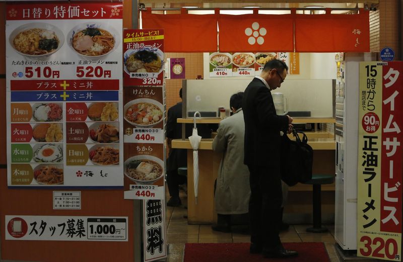 © Reuters. Man buys a food ticket at a restaurant in Tokyo