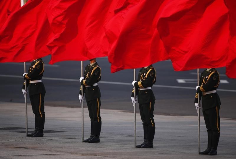 © Reuters. Soldiers of the People's Liberation Army's guard of honour hold flags during the official welcoming ceremony for Serbian President Nikolic in Beijing