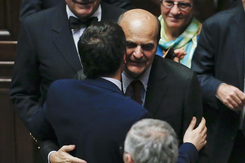 © Reuters. Il premier Matteo Renzi, di spalle, saluta in parlamento l'ex segretario del Pd Pierluigi Bersani 