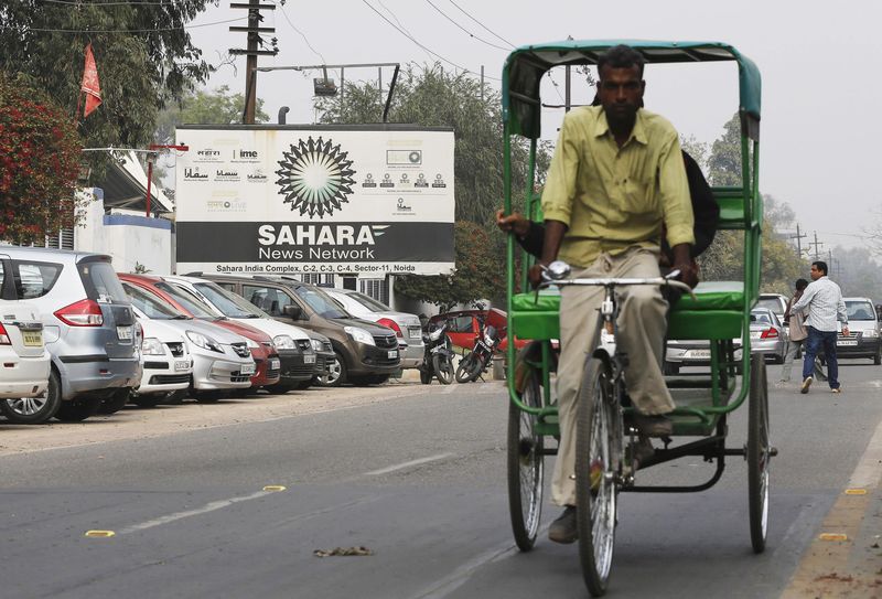 © Reuters. A man pedals his rickshaw past Sahara India Complex building in Noida on the outskirts of New Delhi