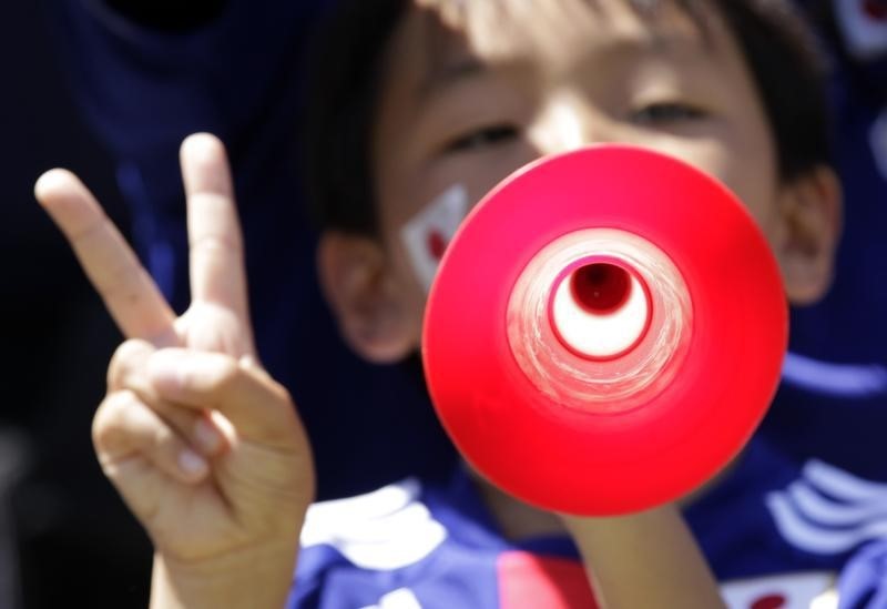 © Reuters. A young Japan soccer supporter plays the vuvuzela before the international friendly soccer match between Japan and Ivory Coast in Sion