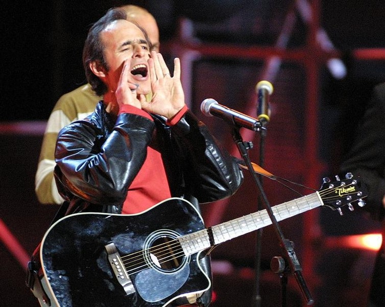 © Reuters. French singer Jean-Jacques Goldman jokes about an electrical failure during his performance at the N..