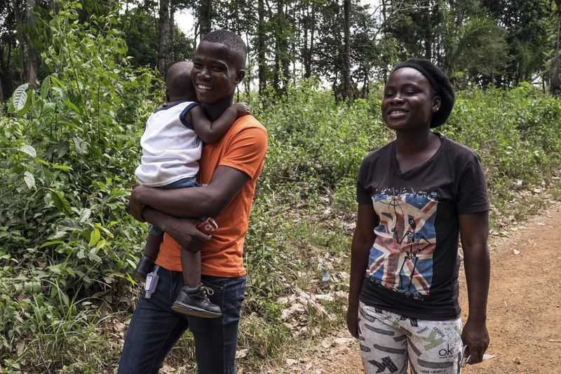 © Reuters. Musa Pabai segura o filho Oliver e caminha ao lado da namorada, Hannah Wright, após encontrá-los pela primeira vez desde sobreviver ao Ebola, em Walakor