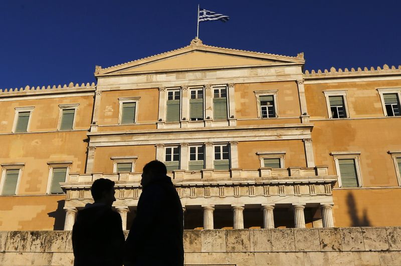 © Reuters. People are silhouetted as they gather ahead of an anti-austerity and pro-government demonstration in front of the parliament in Athens