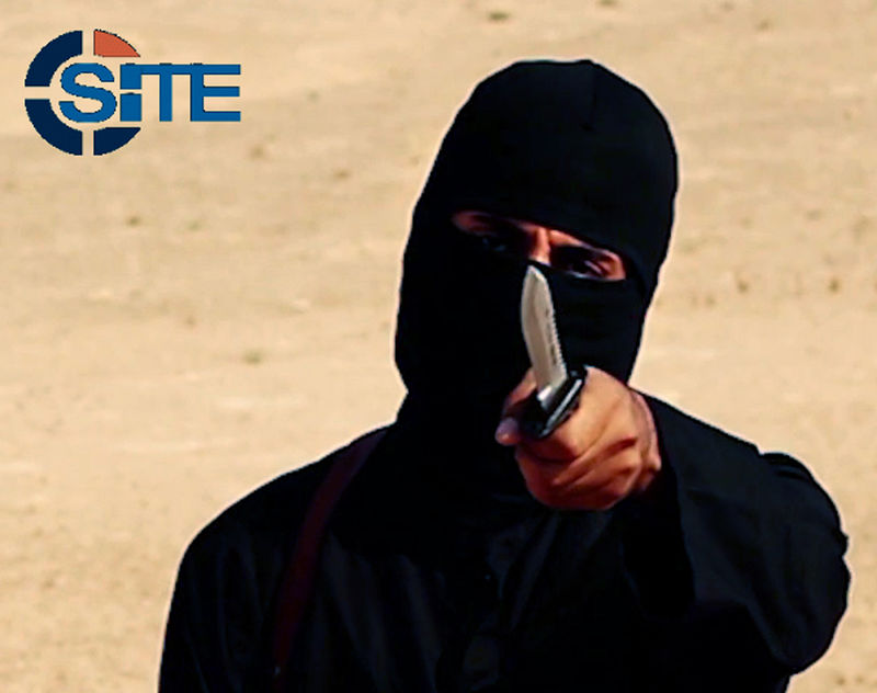 © Reuters. A masked, black-clad militant brandishes a knife in this still image from video