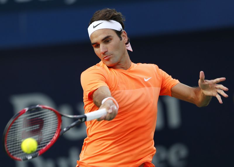 © Reuters. Federer of Switzerland returns the ball to Coric of Croatia during their semi-final match at the ATP Championships tennis tournament in Dubai