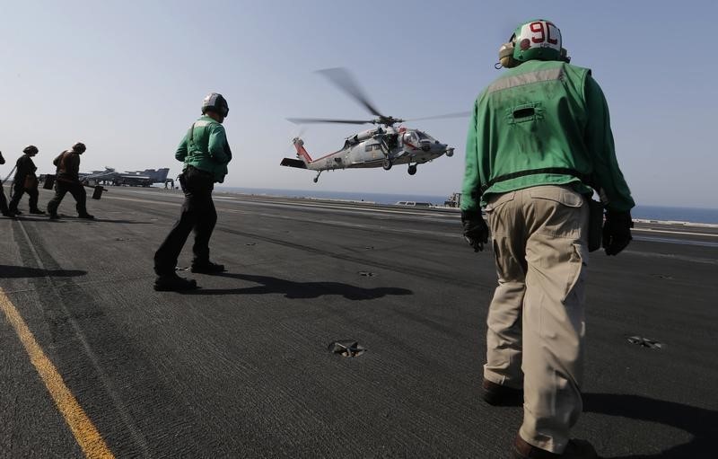 © Reuters. A MH-60S lands on flight deck as crew prepares to receive it onboard the aircraft carrier USS George H.W. Bush, in the Gulf