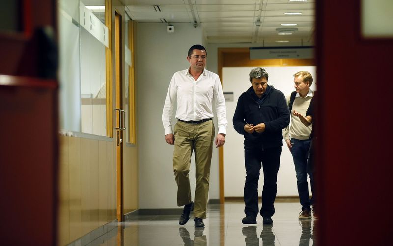 © Reuters. McLaren's team manager Eric Boullier and physiotherapist Fabrizio Borra walk at a corridor in the hospital where McLaren Formula One driver Fernando Alonso of Spain is hospitalized, in Sant Cugat
