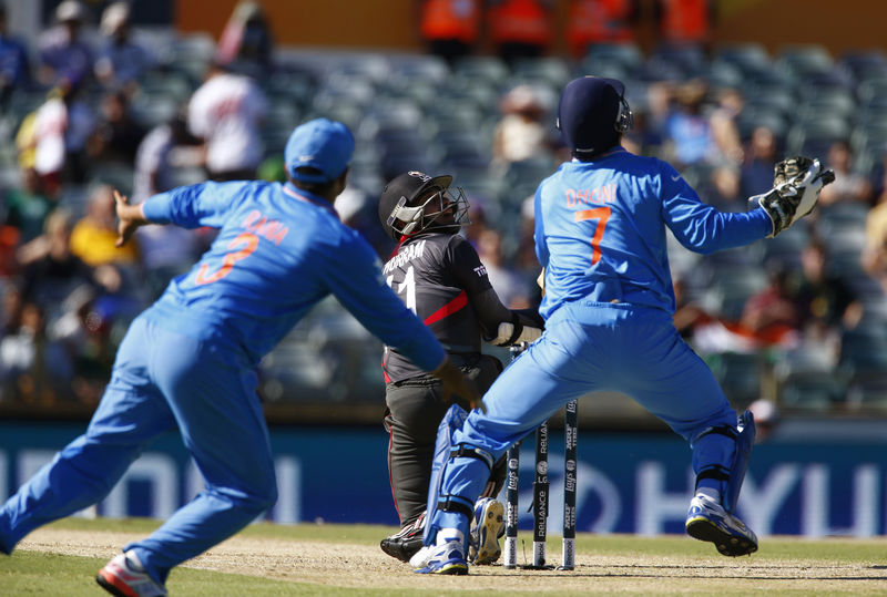 © Reuters. UAE's Khurram Khan hits the ball high off the bowling of India's bowler Ravichandran Ashwin to be caught out eventually by Suresh Raina during their Cricket World Cup match in Perth