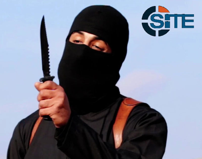 © Reuters. A masked, black-clad militant brandishes a knife in this still image from video