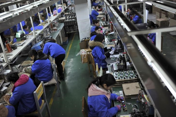 © Reuters. Employees assemble electronic components along a production line at a factory in Hefei