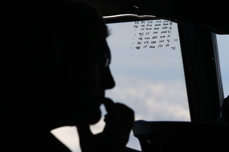 © Reuters. File photo of a crew member aboard a Royal New Zealand Air Force P-3K2 Orion aircraft alongside handwritten notes of other search craft in the area, during a search for the missing Malaysian Airlines MH370 over the Indian Ocean