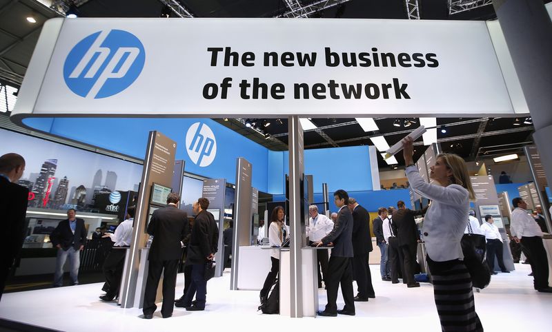 © Reuters. A visitor takes a photo with a tablet in front of a Hewlett-Packard (HP) stand at the Mobile World Congress in Barcelona