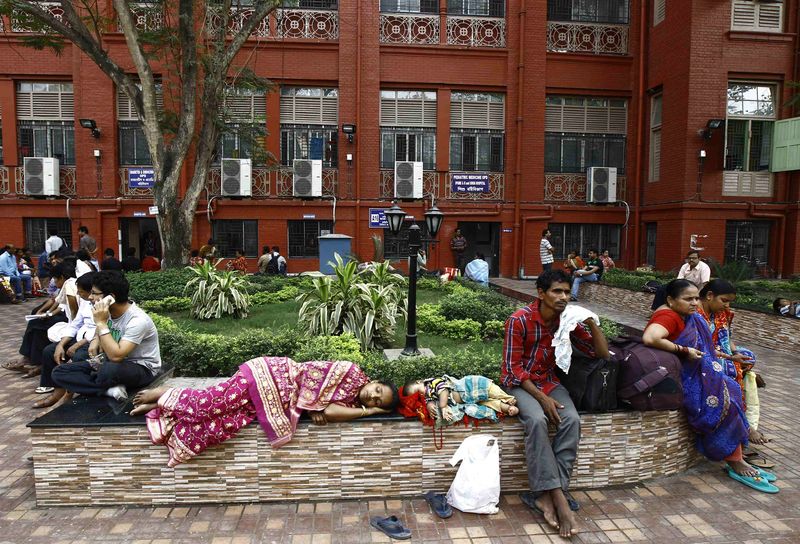 © Reuters. Relatives of patients rest in the premises of a government-run hospital in Kolkata