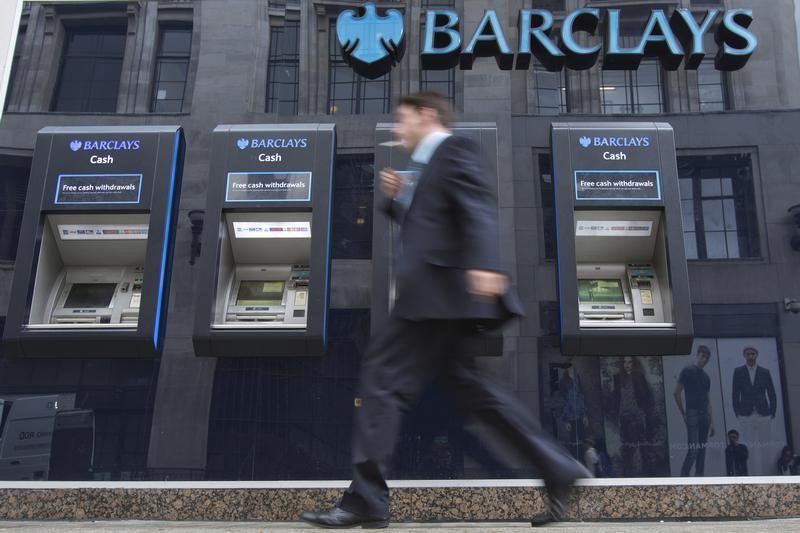© Reuters. A man passes automated teller machines at a Barclays bank branch in London