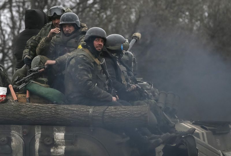 © Reuters. Members of the Ukrainian armed forces ride on an armoured personnel carrier near Artemivsk