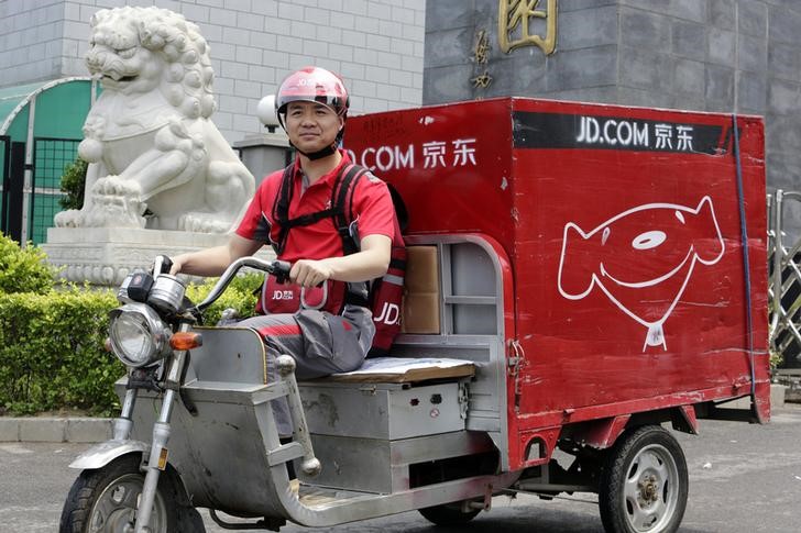 © Reuters. Liu, CEO and founder of China's e-commerce company JD.com, rides an electric tricycle as he makes a delivery run in Beijing